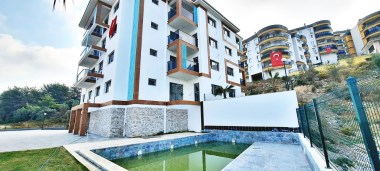 Kuşadası Türkmende Satılık 1+1 Daire Havuzlu Site içinde Doğa ile iç içe Deniz Manzaralı 